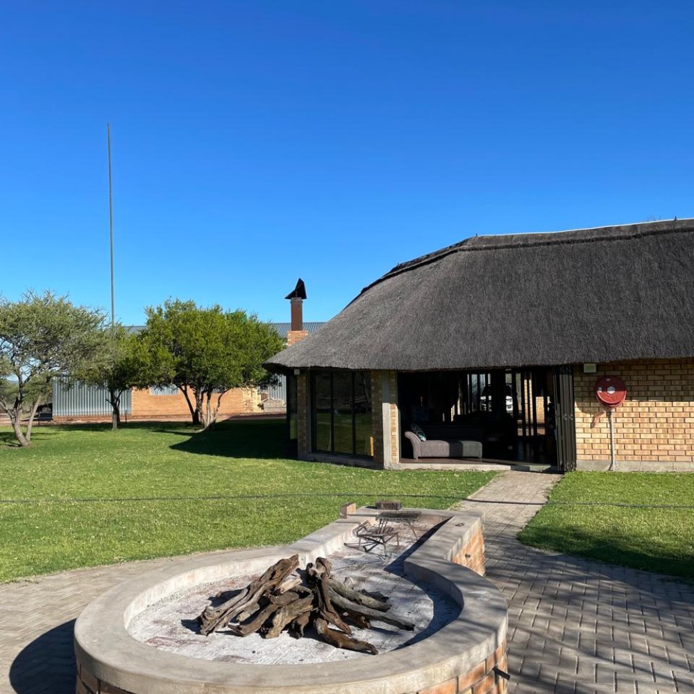 Bandelierkop Lodge exterior — thatched roof with fire pit
