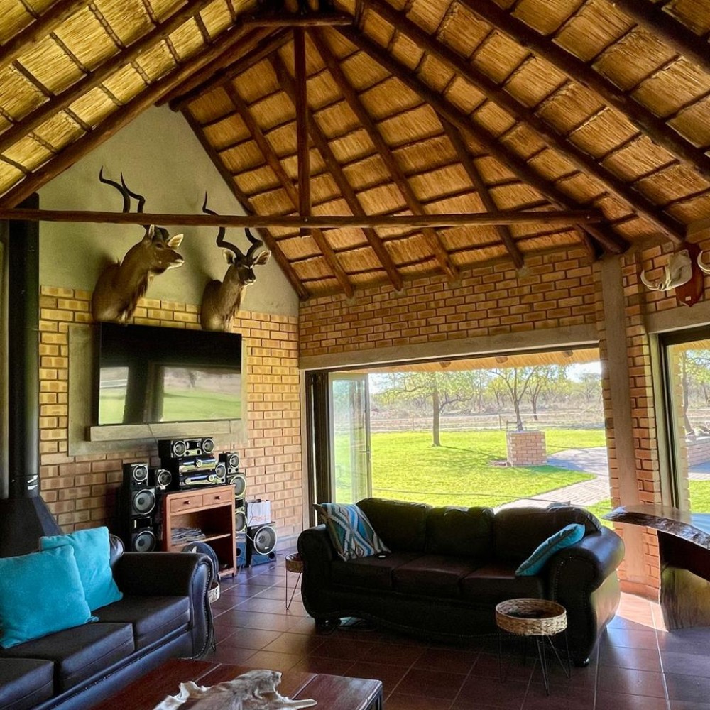 Lodge lounge with kudu mounts and thatched ceiling